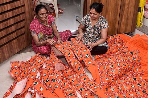 Workers make sashes depicting Bharatiya Janata Party’s logo, in Surat.