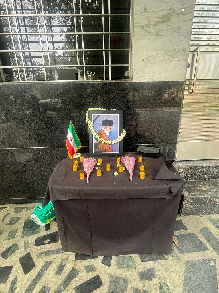 Outside the gates, a small table has been set up. On it rests a photograph of Ayatollah Ali Khamenei, framed by flowers. - Fozia Yasin