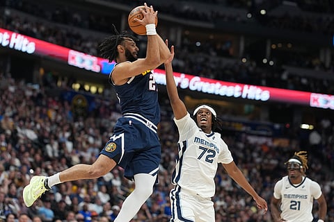 Denver Nuggets guard Jamal Murray, left, fields a pass as Memphis Grizzlies forward Adama Bal defends in the second half of an NBA basketball game in Denver.