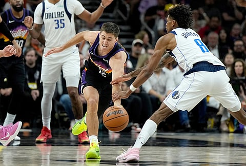 Phoenix Suns guard Collin Gillespie (12) steals the ball from Dallas Mavericks guard AJ Johnson (8) during the second half of an NBA basketball game, in Phoenix.