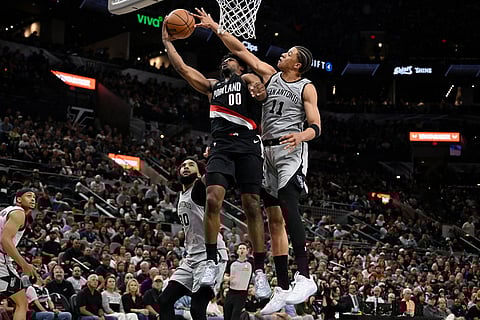 Portland Trail Blazers guard Scoot Henderson (00) is fouled by San Antonio Spurs forward Carter Bryant during the first half of an NBA basketball game in San Antonio.