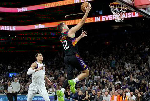 Phoenix Suns guard Collin Gillespie (12) gets past Dallas Mavericks forward Dwight Powell (7) to score during the second half of an NBA basketball game, in Phoenix.