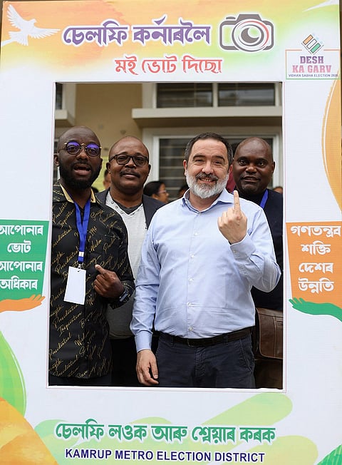 International delegates pose for photographs at a selfie booth during a visit to Ulubari polling station under the International Election Visitors’ Programme (IEVP), amid the ongoing Assam Assembly elections, in Guwahati. 
