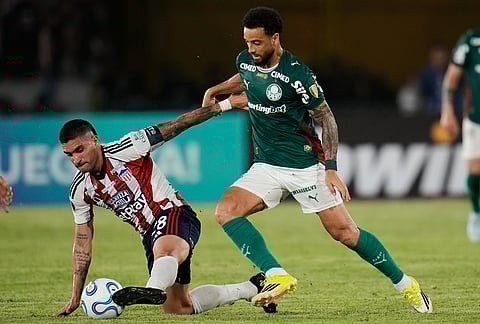 Guillermom Celis of Colombia's Junior, left, and Felipe Anderson of Brazil's Palmeiras battle for the ball during a Copa Libertadores Group F soccer match in Cartagena, Colombia.
