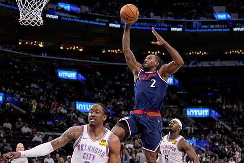 Los Angeles Clippers forward Kawhi Leonard, center, dunks as Oklahoma City Thunder guard Jalen Williams, left, and guard Luguentz Dort defend during the second half of an NBA basketball game in Inglewood, Calif.