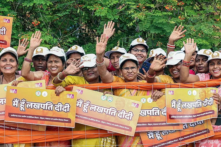 People holding posters of Lakhpati Didi Scheme posters during a roadshow of Prime Minister Narendra Modi, in Nava Raipur, Chattisgarh - Photo: IMAGO/ANI News