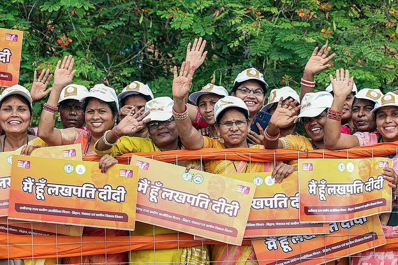 People holding posters of Lakhpati Didi Scheme posters