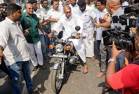 Puducherry Chief Minister N Rangasamy leaves on a motorcycle after casting vote during the Puducherry Assembly elections, at a polling station in Puducherry.