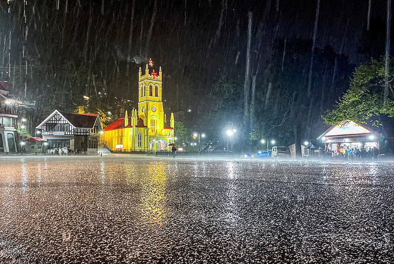Shimla: People take cover during a hailstorm and rain at the Ridge,