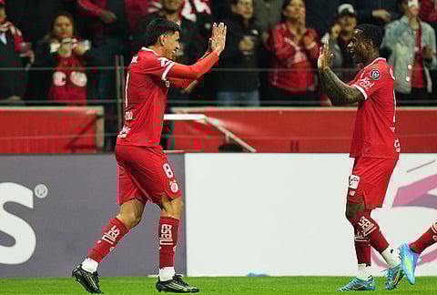 Nico Castro of Mexico's Toluca, left, celebrates scoring his side's opening goal against the United States' LA Galaxy during a CONCACAF Champions Cup quarterfinal first leg soccer match in Toluca, Mexico.