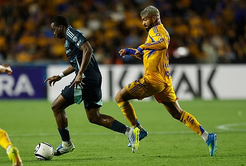 Nouhou Tolo of the United States' Seattle Sounders, left, is followed by Rodrigo Aguirre of Mexico's Tigres during a CONCACAF Champions Cup quarterfinal first leg soccer match in Monterrey, Mexico.
