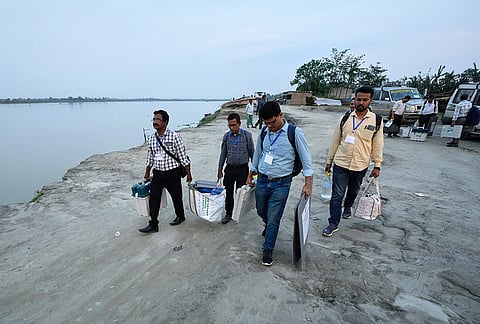 Polling officials carry voting machines and other election material to travel to their polling booths, on the eve of the state election in Garoimari village on the outskirts of Guwahati, India, Wednesday, April 8, 2026. 