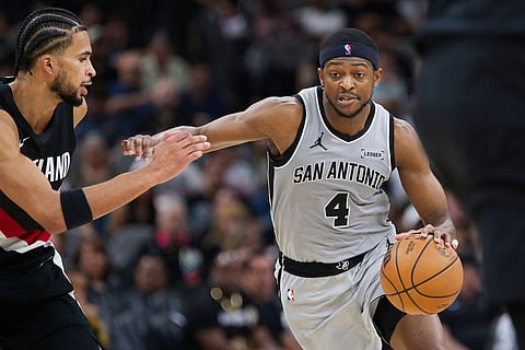 San Antonio Spurs guard De'Aaron Fox (4) drives against Portland Trail Blazers forward Toumani Camara during the second half of an NBA basketball game in San Antonio.