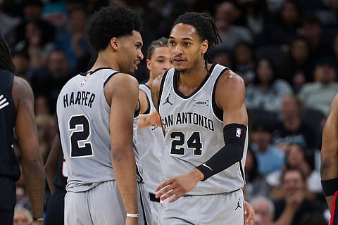 San Antonio Spurs guard Devin Vassell (24) celebrates a basket with teammate Dylan Harper during the first half of their NBA basketball game against the Portland Trail Blazers in San Antonio.