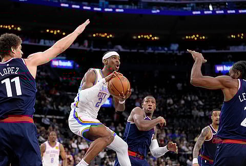 Oklahoma City Thunder guard Shai Gilgeous-Alexander, second from left, passes as Los Angeles Clippers center Brook Lopez, left, guard Kris Dunn, center, forward John Collins, second from right, and forward Kawhi Leonard defend during the first half of an NBA basketball game in Inglewood, California.