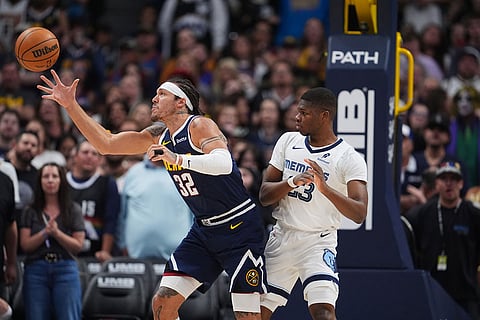Denver Nuggets forward Aaron Gordon, left, pulls in a loose ball as Memphis Grizzlies guard Cedric Coward defends in the first half of an NBA basketball game in Denver. 