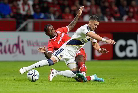 Helinho of Mexico's Toluca, back, and Erik Thommy of the United States' LA Galaxy battle for the ball during a CONCACAF Champions Cup quarterfinal first leg soccer match in Toluca, Mexico.