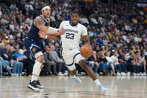 Memphis Grizzlies guard Cedric Coward, right, drives past Denver Nuggets forward Aaron Gordon in the first half of an NBA basketball game in Denver.
