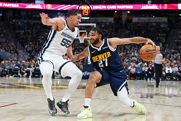 Denver Nuggets guard Jamal Murray, right, drives to the rim as Memphis Grizzlies guard Lucas Williamson defends in the second half of an NBA basketball game in Denver. - | Photo: AP/David Zalubowski