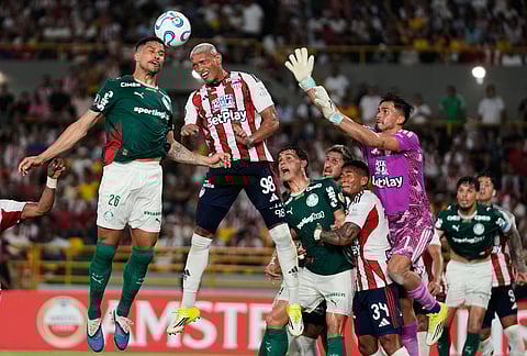Murilo of Brazil's Palmeiras (26) and Jermein Pena of Colombia's Junior go for a header during a Copa Libertadores Group F soccer match in Cartagena, Colombia.