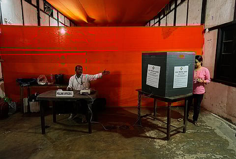 A woman casts her vote at a polling center during the state election in Guwahati.