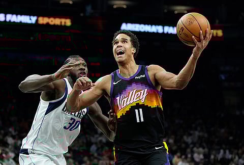 Phoenix Suns forward Oso Ighodaro (11) drives past Dallas Mavericks center Moussa Cisse (30) to score during the first half of an NBA basketball game, in Phoenix.