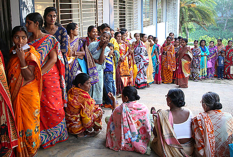 People wait in a queue to cast their votes in the by-election to the Dharmanagar Assembly constituency, in North Tripura district.