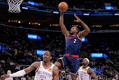 Los Angeles Clippers forward Kawhi Leonard, center, dunks as Oklahoma City Thunder guard Jalen Williams, left, and guard Luguentz Dort defend during the second half of an NBA basketball game in Inglewood, California.