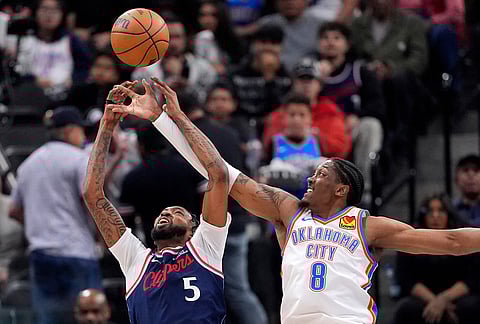 Los Angeles Clippers forward Derrick Jones Jr., left, and Oklahoma City Thunder guard Jalen Williams reach for a rebound during the first half of an NBA basketball game in Inglewood, California.