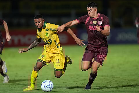 Negueba of Brazil's Mirassol, left, is challenged by Agustin Cardozo of Argentina's Lanus during a Copa Libertadores Group G soccer match in Mirassol, Sao Paulo state.
