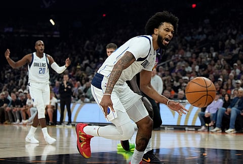 Dallas Mavericks forward Marvin Bagley III, right, is unable to control the ball on a pass from Mavericks forward Khris Middleton (20) during the first half of an NBA basketball game against the Phoenix Suns, in Phoenix.