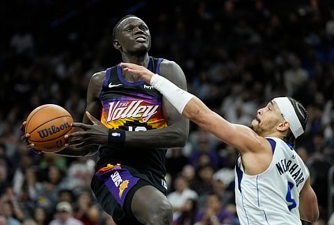 Phoenix Suns center Khaman Maluach, left, drives to the basket against Dallas Mavericks guard Ryan Nembhard, right, during the second half of an NBA basketball game, in Phoenix.