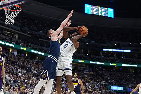 Memphis Grizzlies forward Toby Okani, right, goes up for a shot as Denver Nuggets guard Christian Braun defends in the first half of an NBA basketball in Denver.
