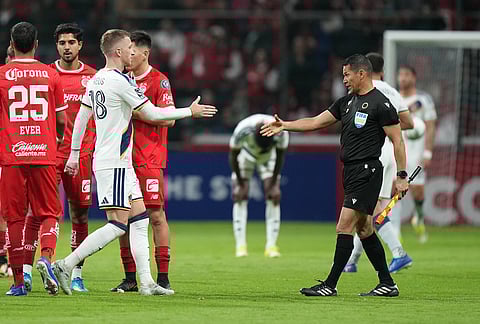 Marco Reus of the United States' LA Galaxy, left, shakes hands with a referee at the end of a CONCACAF Champions Cup quarterfinal first leg soccer match in Toluca, Mexico.