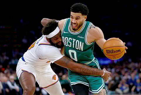 New York Knicks center Mitchell Robinson, left, defends Boston Celtics guard Jayson Tatum during the second half of an NBA basketball game in New York. 