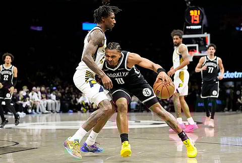 Brooklyn Nets guard Tyson Etienne (10) drives past Indiana Pacers guard Quenton Jackson, center left, during the second half of an NBA basketball game, in New York. 