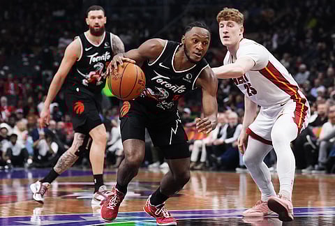 Toronto Raptors' Immanuel Quickley (5) drives past Miami Heat's Kasparas Jakucionis (25) during the first period of an NBA game.