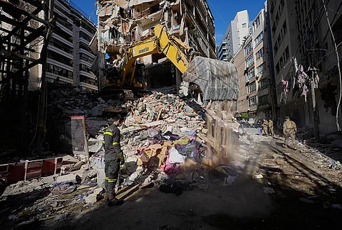 A Lebanese civil defense worker looks on as an excavator operates on the rubble of a building destroyed in an Israeli airstrike a day earlier in Beirut, Lebanon, Thursday, April 9, 2026. 
