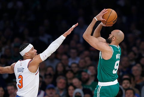 New York Knicks guard Josh Hart, left, defends Boston Celtics guard Derrick White during the first half of an NBA basketball game in New York.