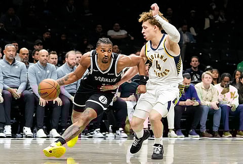 Brooklyn Nets guard Tyson Etienne, left, drives past Indiana Pacers guard Taelon Peter (4) during the second half of an NBA basketball game, in New York.