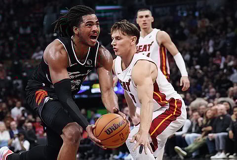 Toronto Raptors' Collin Murray-Boyles (left) drives past Miami Heat's Pelle Larsson (9) during the first period of an NBA game.