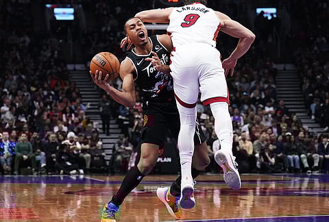 Toronto Raptors' Scottie Barnes (left) is fouled by Miami Heat's Pelle Larsson (9) during the first period of an NBA game.
