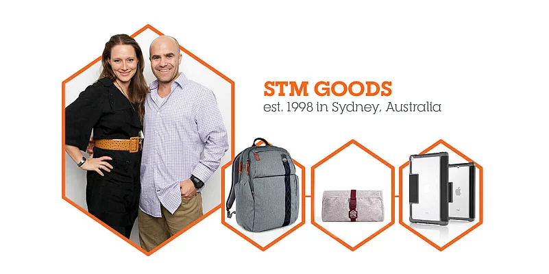 A man and woman stand next to products by STM Goods