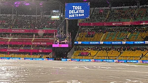 | Photo: PTI/Swapan Mahapatra : View of the ground covered due to rain as a screen displays 'Toss delayed due to rain' during an Indian Premier League (IPL) 2026 T20 cricket match between Rajasthan Royals and Mumbai Indians, in Guwahati.