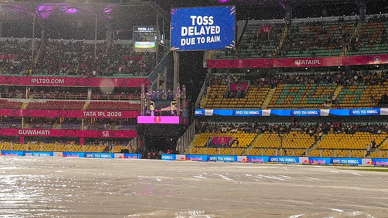View of the ground covered due to rain as a screen displays 'Toss delayed due to rain' during an Indian Premier League (IPL) 2026 T20 cricket match between Rajasthan Royals and Mumbai Indians, in Guwahati. - | Photo: PTI/Swapan Mahapatra