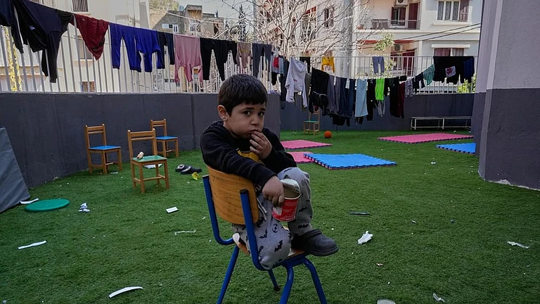 A displaced boy who fled Israeli strikes in southern Lebanon with his family sits on the backyard school that turned into a shelter in Beirut, Lebanon, Tuesday, March 10, 2026. - | Photo: AP/Hussein Malla