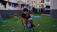 | Photo: AP/Hussein Malla : A displaced boy who fled Israeli strikes in southern Lebanon with his family sits on the backyard school that turned into a shelter in Beirut, Lebanon, Tuesday, March 10, 2026. 