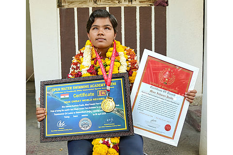 Ishwari Pande, a visually impaired swimmer, shows her medals and certificates after setting a record by completing the 25-km Palk Strait stretch from Talaimannar to Dhanushkodi in 11 hours, in Nagpur.