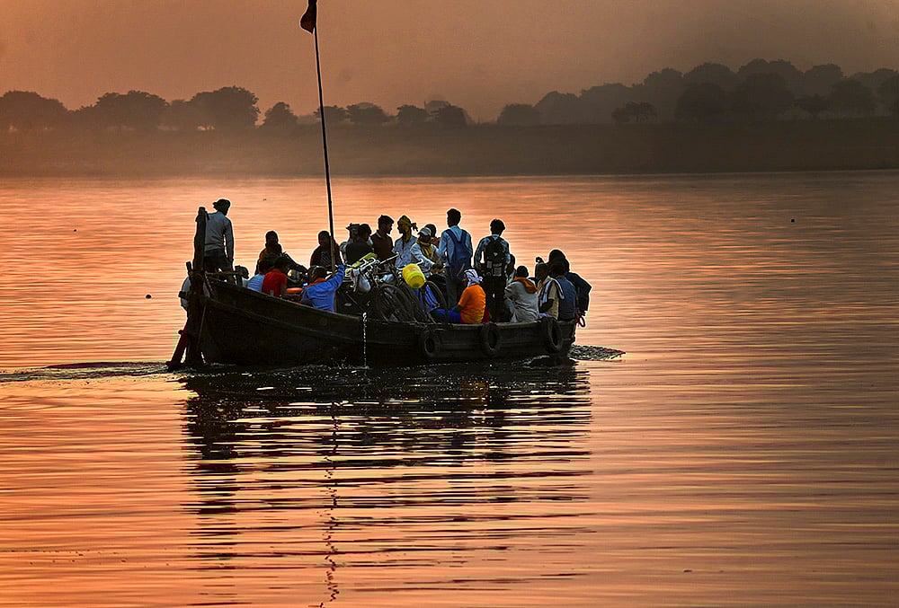 Commuters cross Ganga by boat at sunset in Patna