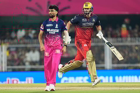 Royal Challengers Bengaluru's Tim David takes a run as Rajasthan Royals' Brijesh Sharma looks on during the Indian Premier League cricket match between Royal Challengers Bengaluru and Rajasthan Royals in Guwahati, India.